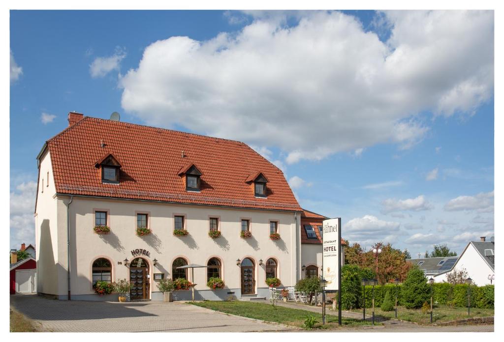 ein großes weißes Gebäude mit rotem Dach in der Unterkunft Hotel & Restaurant Hähnel in Bannewitz