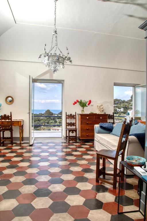 salon z szafowaną podłogą i żyrandolem w obiekcie Casa Cantasol - Capri w mieście Capri