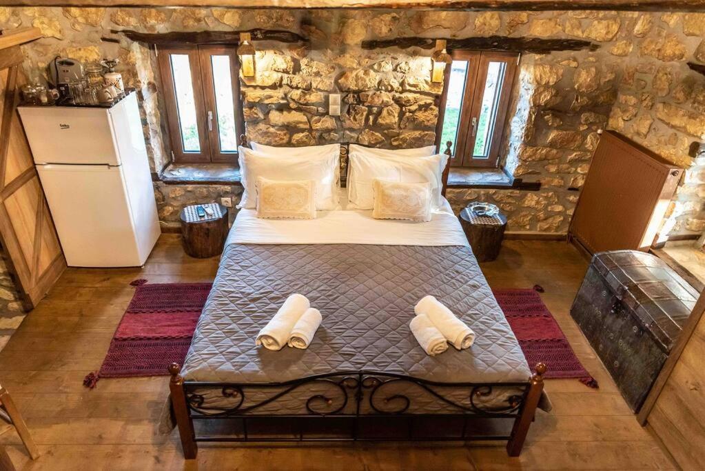 a bedroom with a bed in a stone house at Traditional Stone Guesthouse in Áyios Ioánnis