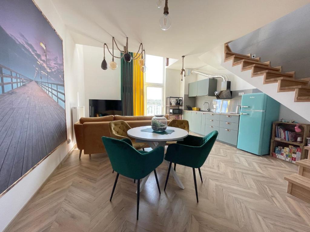 Apartament Przystań في ميكلينكي: مطبخ وغرفة معيشة مع طاولة وكراسي