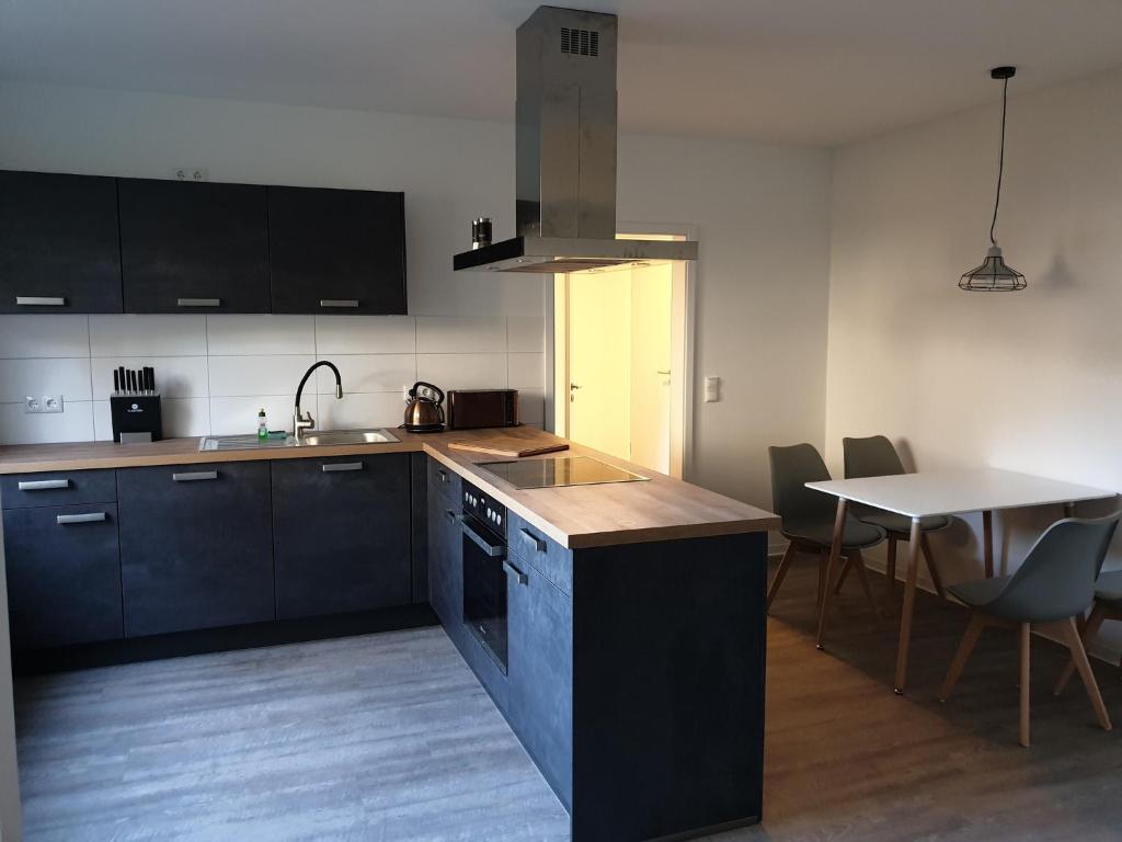 una cocina con armarios negros y una mesa con sillas en Quaduxenbarg - a65754, en Rüggow