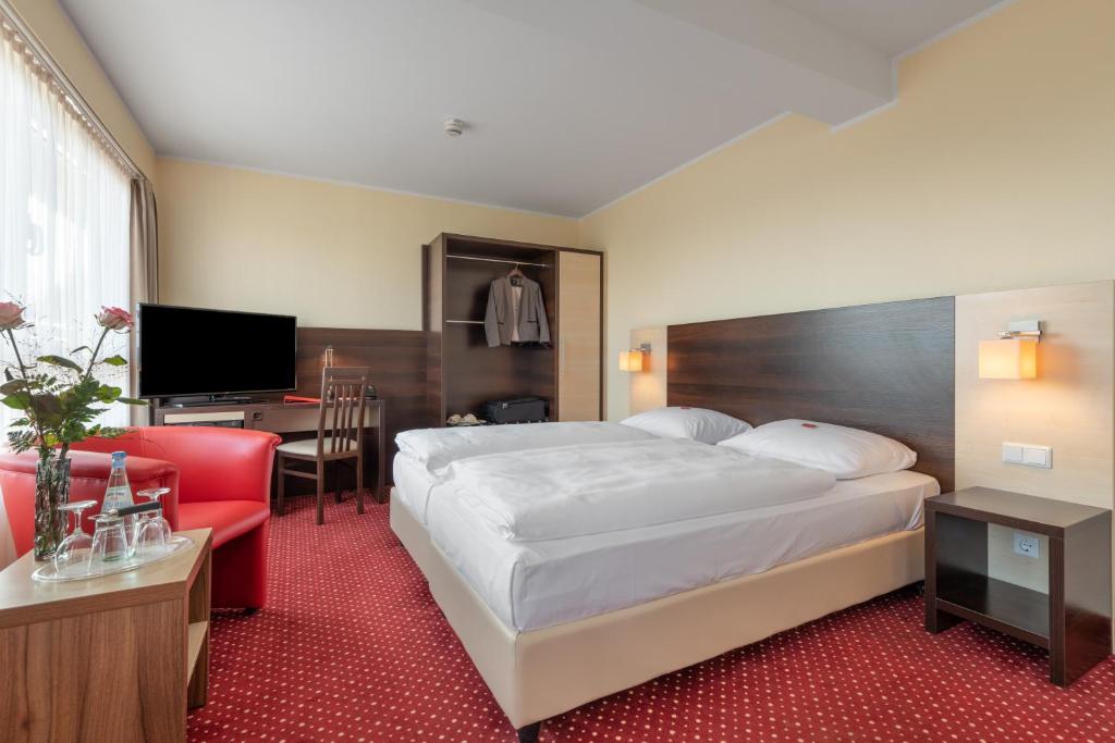 a hotel room with a bed and a desk at acom Hotel Berlin City Sued in Berlin
