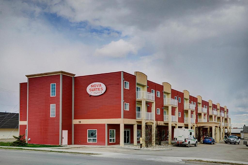 ein großes rotes Gebäude mit einem Hotel in der Unterkunft Nova Inn Edson in Edson