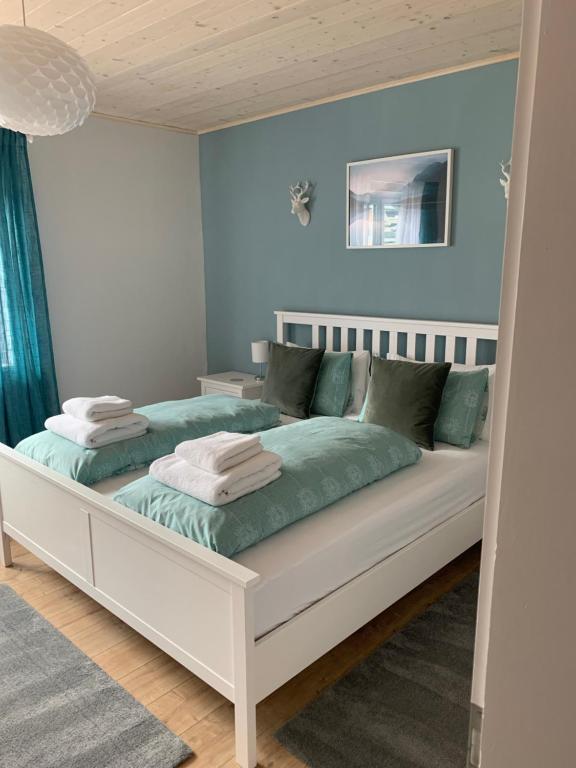 a bedroom with a large white bed with blue walls at Apartment Armstrong in Gundersheim