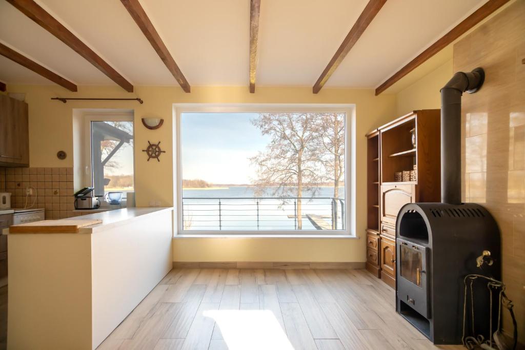 a kitchen with a large window and a stove at Lake House Listomie in Kruszwin