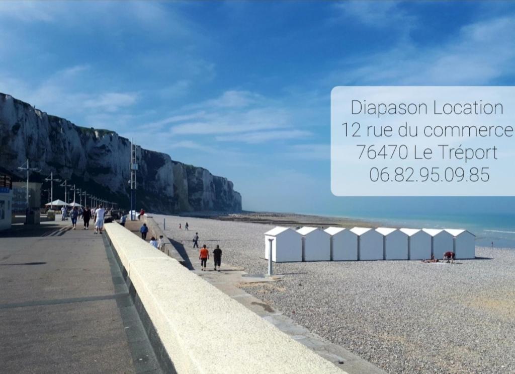 Una vista de una playa con gente caminando en ella en Diapason Location Le Tréport pour 5 personnes en Le Tréport