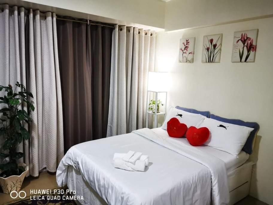 - une chambre avec deux cœurs rouges sur un lit dans l'établissement Staycation Condotel @150newport pasay city, à Manille
