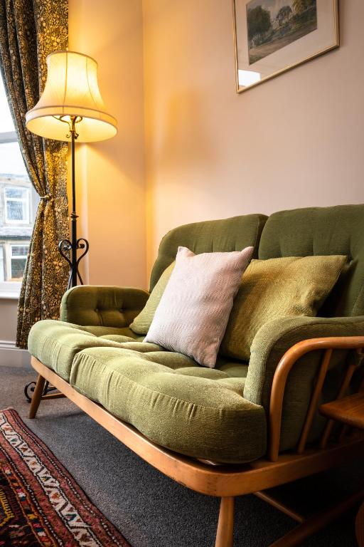 a green couch in a living room with a lamp at CRAVEN VUE - SKIPTON in Skipton