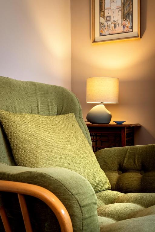 a green couch with a lamp on a table at CRAVEN VUE - SKIPTON in Skipton