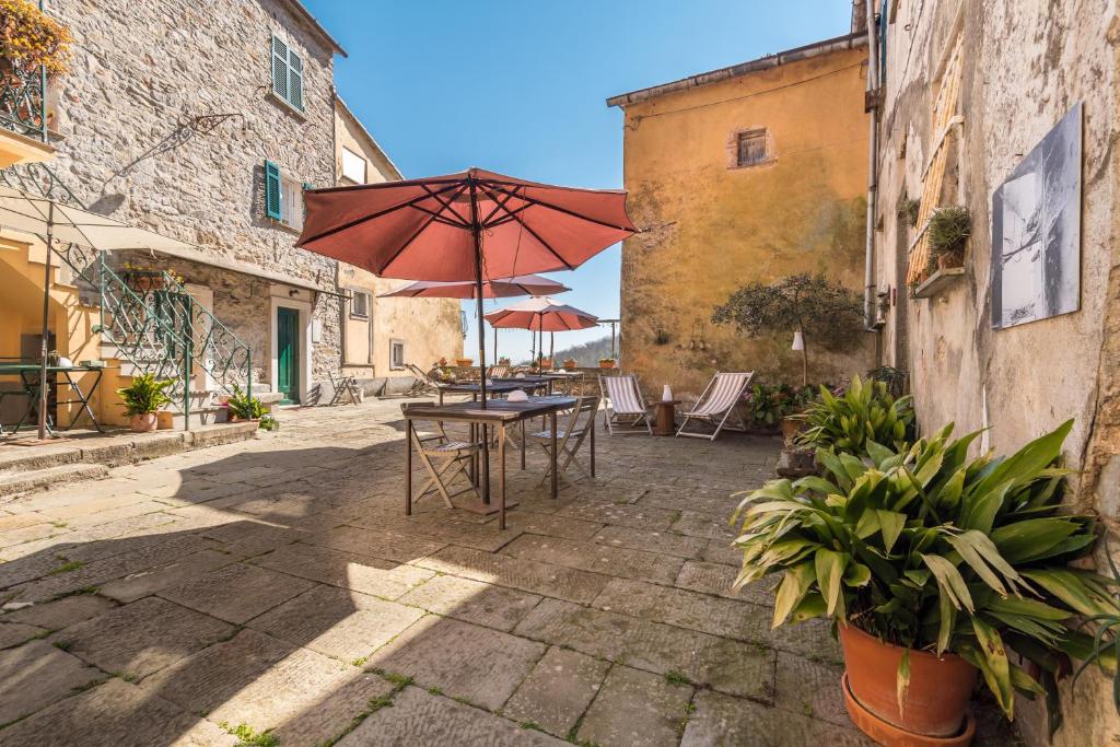 a patio with a table and an umbrella at Corte Paganini Casa Vacanze in Riccò del Golfo di Spezia