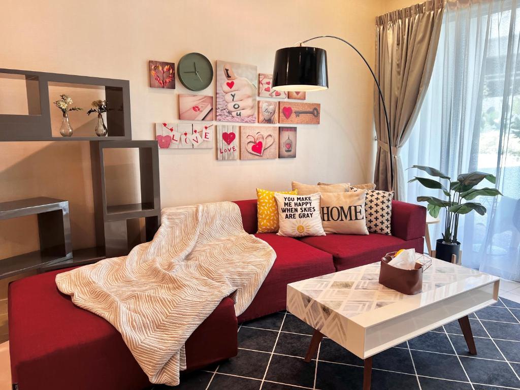 ein Wohnzimmer mit einem roten Sofa und einem Tisch in der Unterkunft Deco Home @ Imago The Loft in Kota Kinabalu