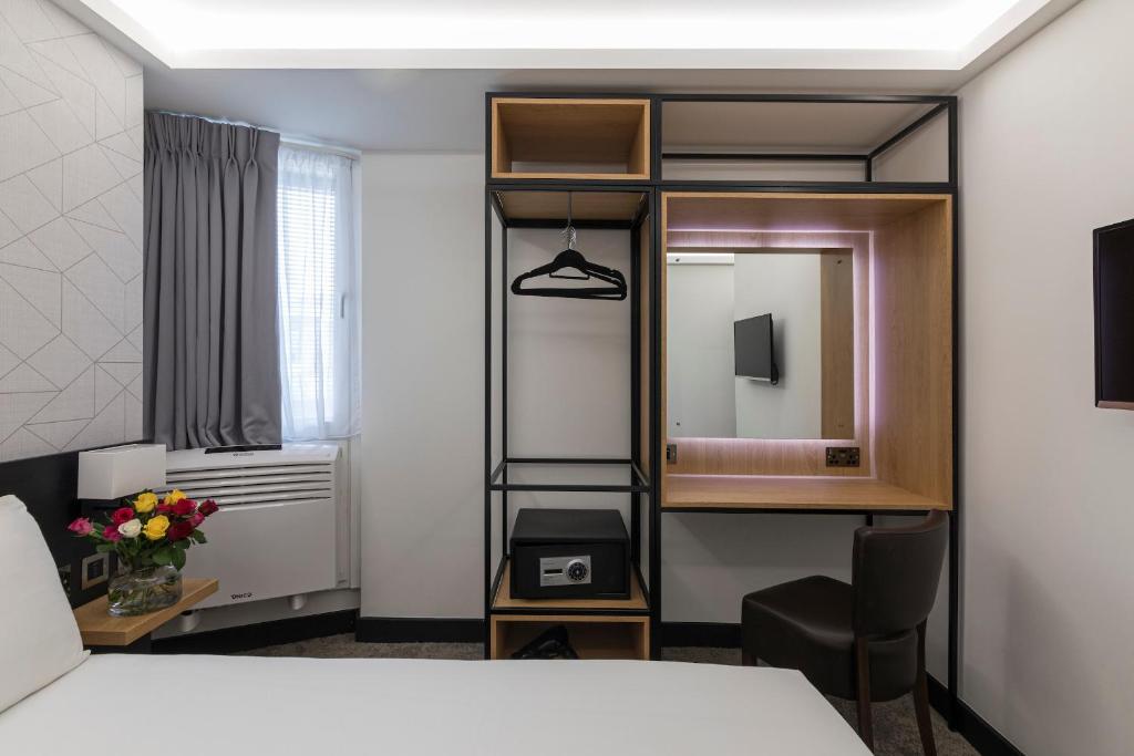 a hotel room with a bed and a mirror at St Giles London – A St Giles Hotel in London