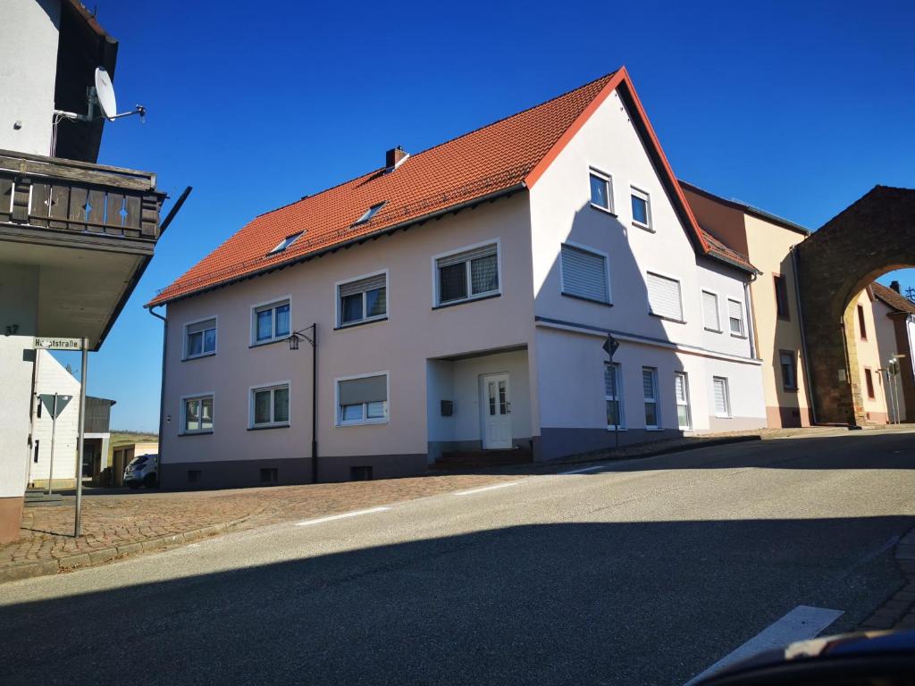 a white building with a red roof on a street at Ferienwohnung Gebauer in Hornbach