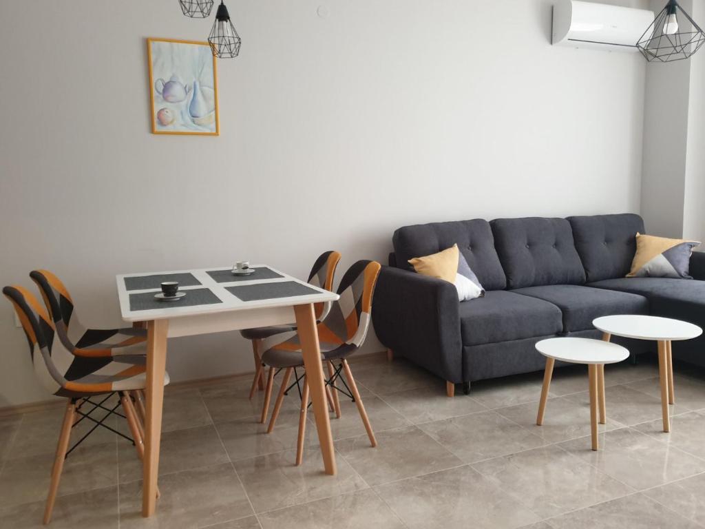 ein Wohnzimmer mit einem Sofa, einem Tisch und Stühlen in der Unterkunft Pirotska 47 apartment in Sofia
