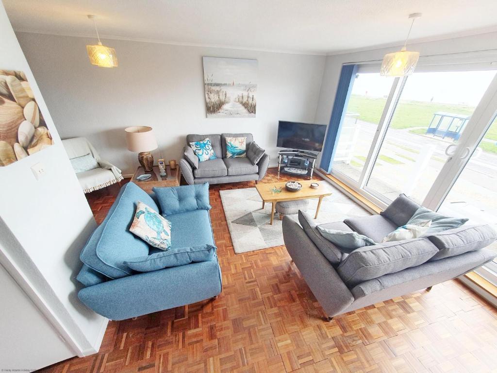 a living room with two couches and a table at Sea Breeze, Selsey in Selsey