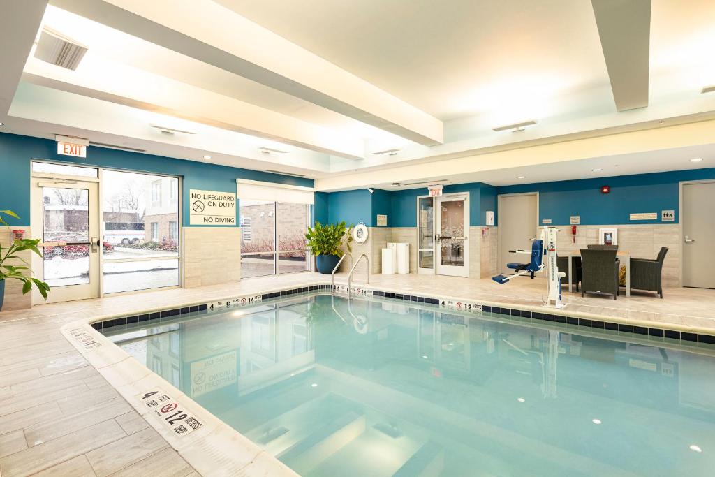 une grande piscine dans le hall de l'hôtel dans l'établissement Hampton Inn Buffalo - Amherst, à Amherst