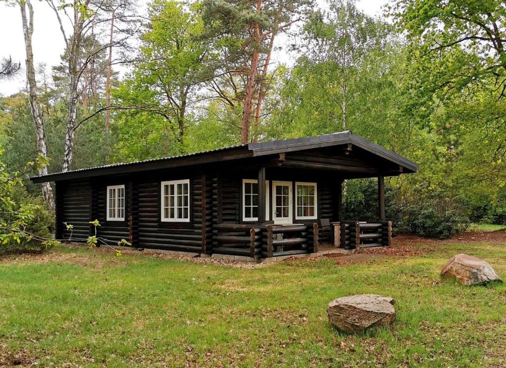 una cabaña de madera en medio de un campo en Scandinavian Lodges (by Outdoors Holten) en Holten