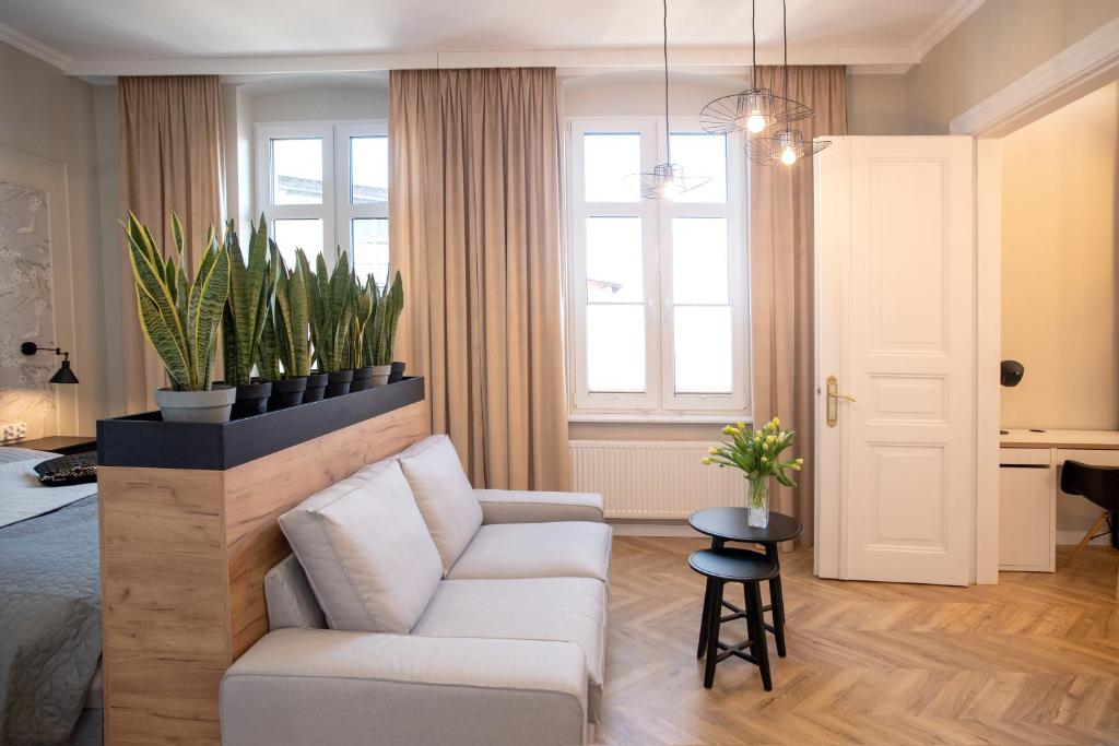 a living room with a white couch and a window at Apartament Rynek 12 Kościerzyna in Kościerzyna