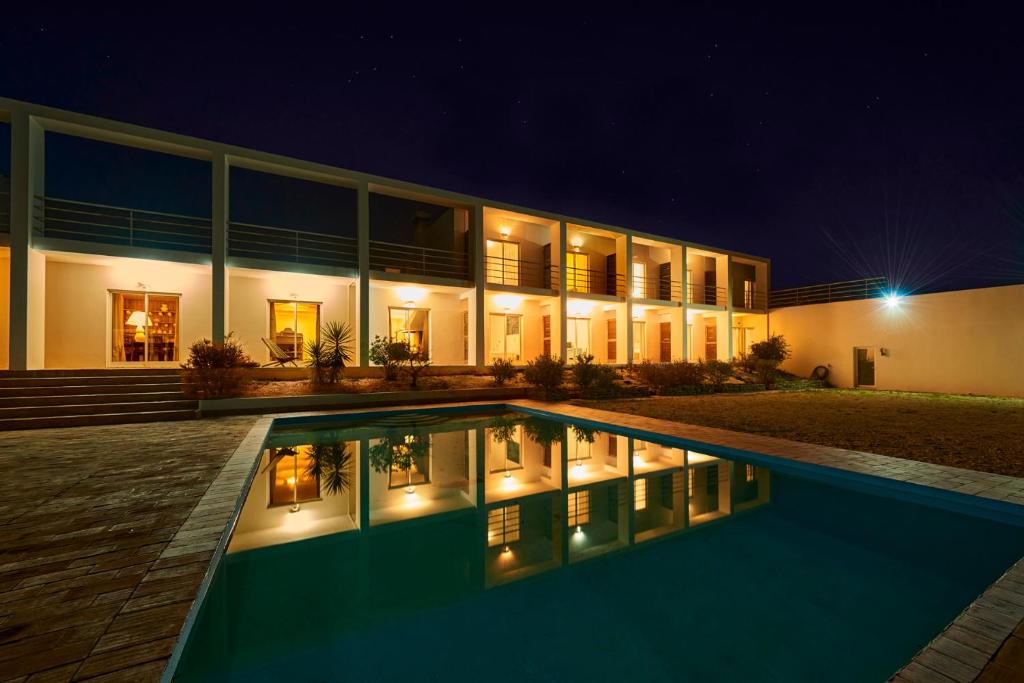 una casa con piscina por la noche en Alto da Lua, en Aljezur