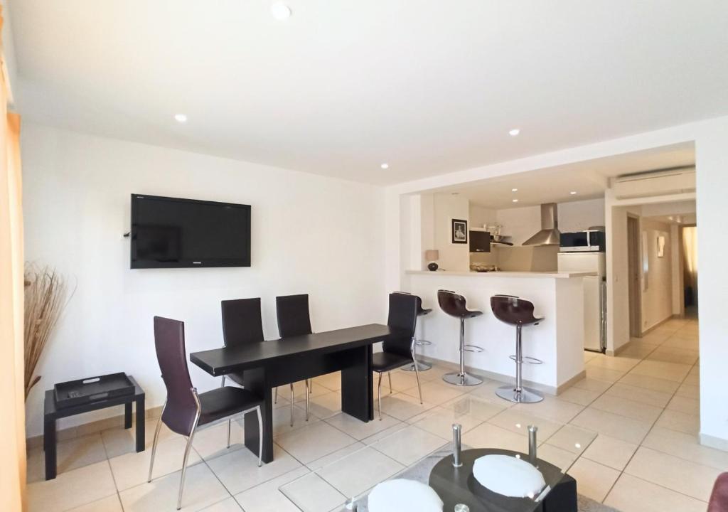 un salon avec une table et des chaises noires dans l'établissement Viva Riviera 2 Bedrooms 2 Bathrooms Rue Florian, à Cannes