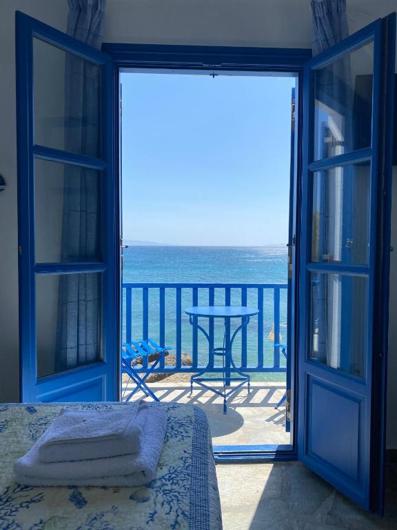 a bedroom with a view of the ocean from a balcony at Cavos Studio by the sea (West) in Drios