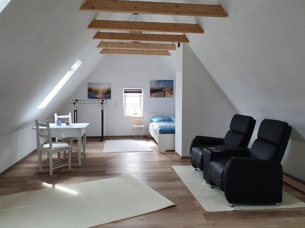 sala de estar con sillas negras y mesa en Ferienwohnung Deubetal 10, en Stadtilm