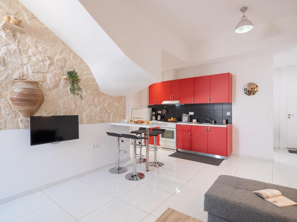 a kitchen with red cabinets and a white floor at Palm House near Heraklion Airport in Heraklio Town