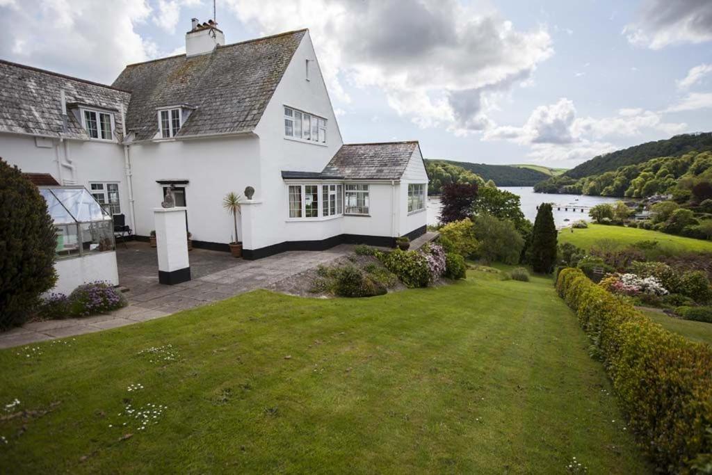 a large white house with a large yard at Pipiriki - Spectacular views and outstanding garden in peaceful location in Dittisham