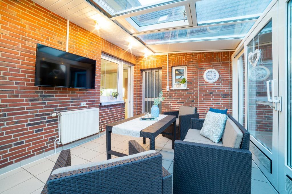 a patio with a table and chairs and a tv at Ferienwohnung Bernd in Lathen