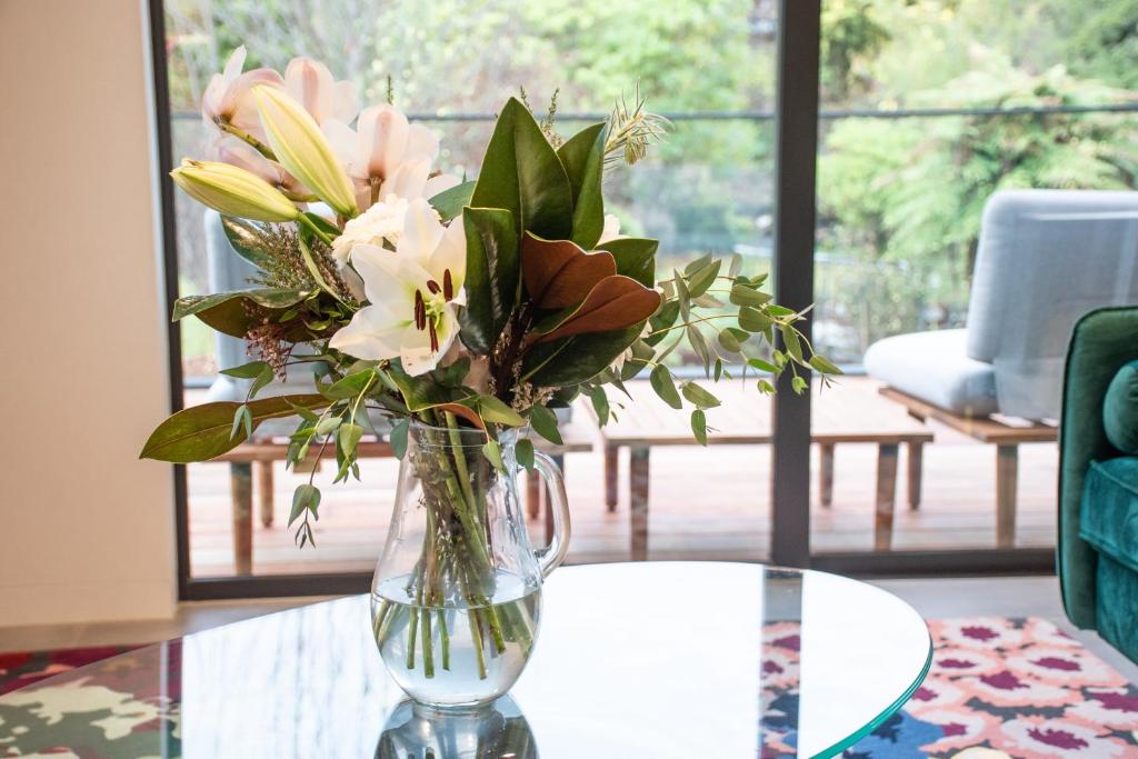 a vase filled with flowers sitting on a table at Brookside Central Wanaka Luxury Apartment in Wanaka