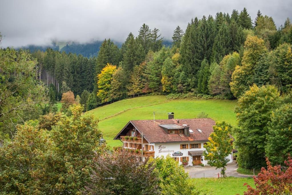 une maison au milieu d'un champ arboré dans l'établissement Apartment Chalet Rubihorn mit Berg-Blick, à Bolsterlang