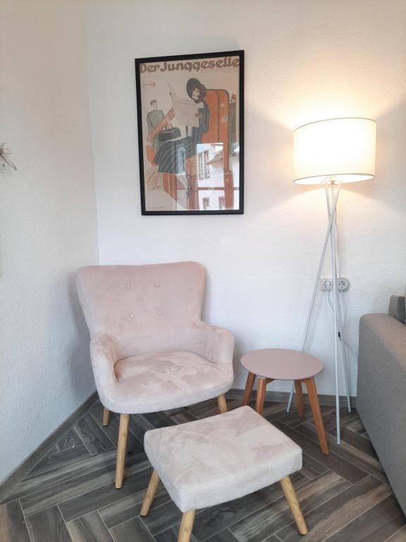 a living room with a chair and a table at Ferienwohnung Langenberg Altstadt WiFi Netflix in Velbert