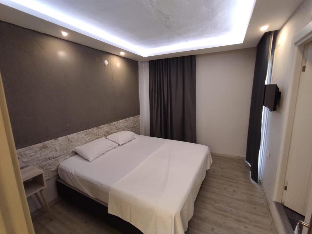1 dormitorio con 1 cama blanca en una habitación en 1989 hotel sebat, en Cesme