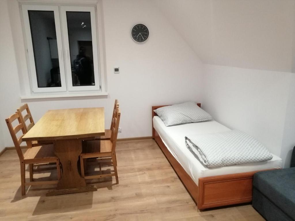 Zimmer mit einem Tisch, einem Bett und einem Schreibtisch in der Unterkunft Apartament nad Muflonem in Podgórzyn