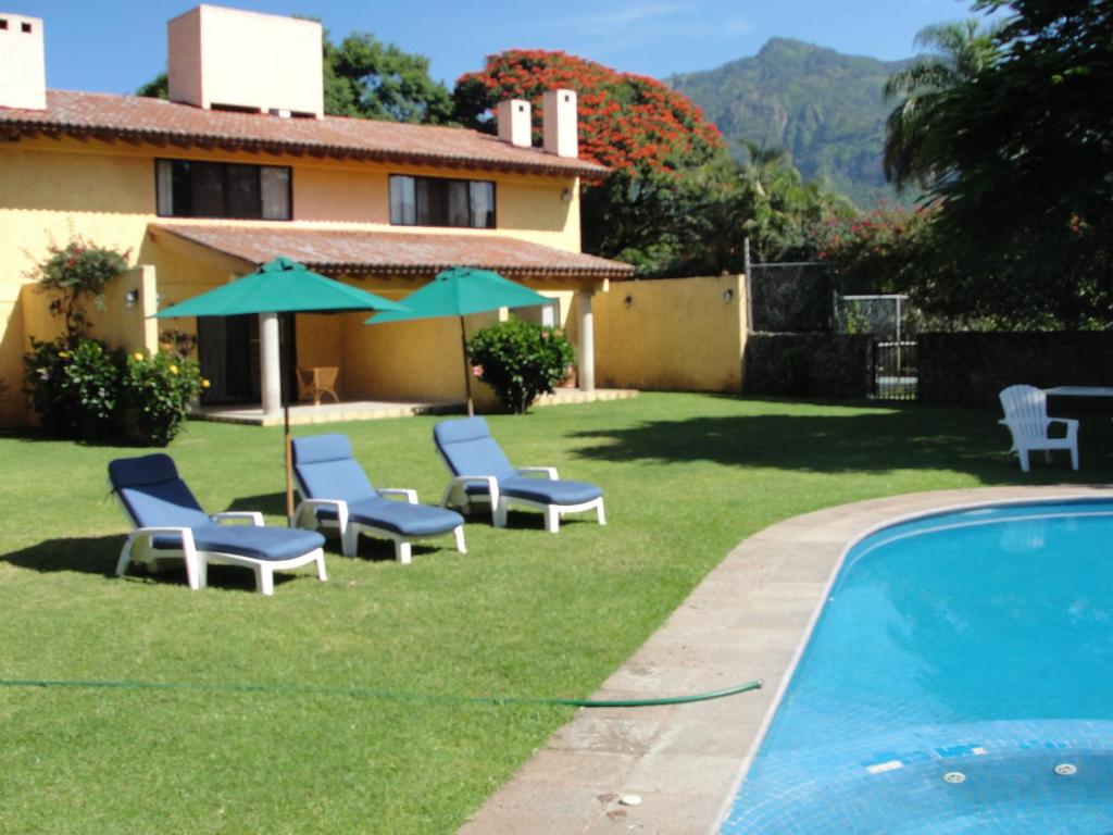 un patio con sillas, una piscina y una casa en Las Casitas Tepoztlán, en Tepoztlán