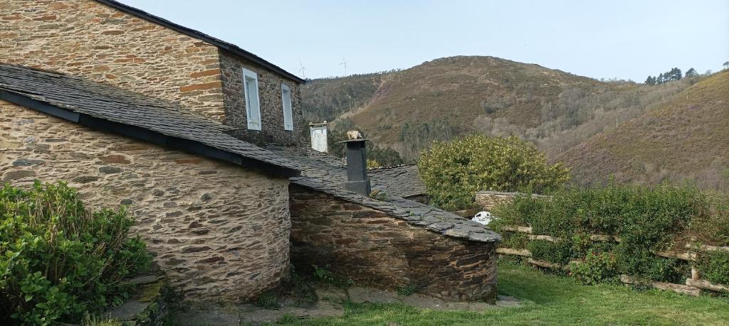 a stone house in the mountains with mountains in the background at CASA DA POUPARIÑA in Deveso