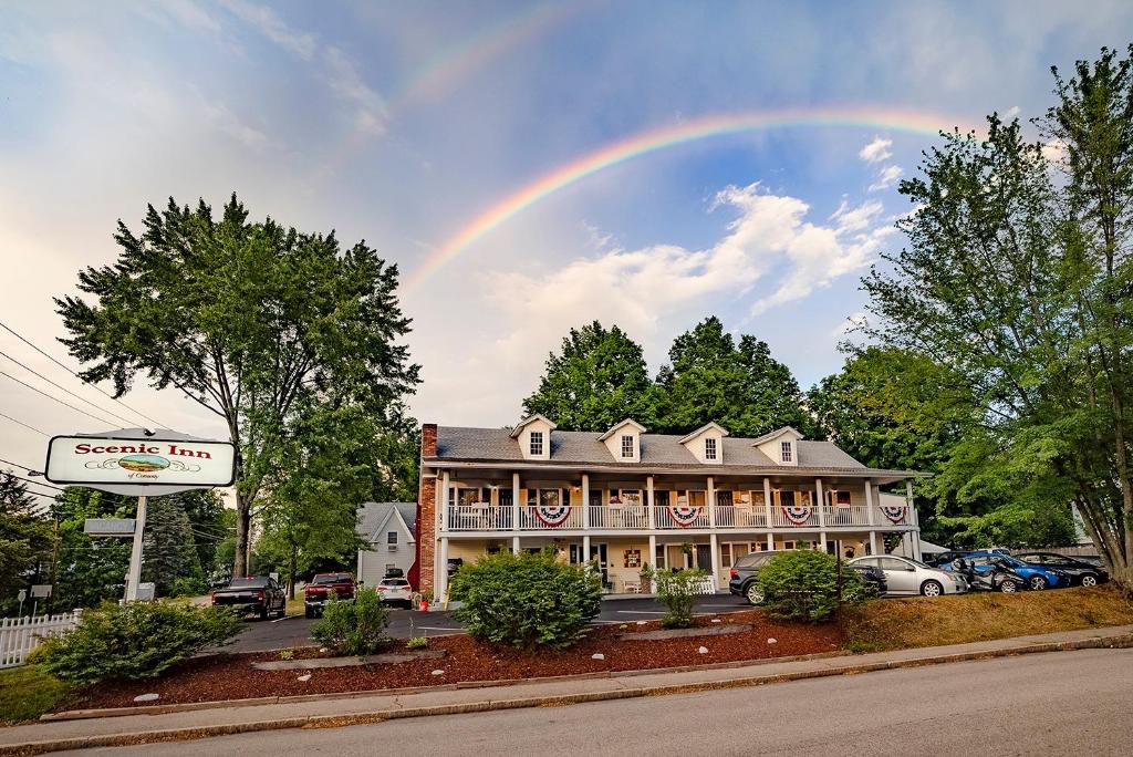 um arco-íris no céu acima de uma grande casa em Scenic Inn em Conway