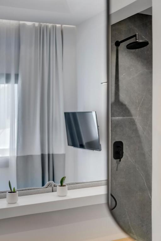 Televízia a/alebo spoločenská miestnosť v ubytovaní Times Elegant Rooms