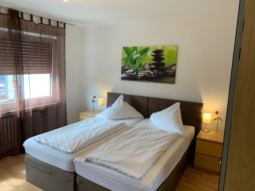 sypialnia z łóżkiem z białą pościelą i oknem w obiekcie Hotel Restaurant Latio w Kolonii