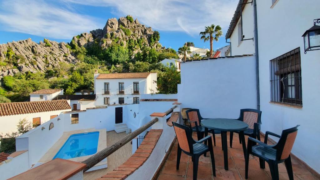 a balcony with chairs and a table and a swimming pool at Casita del Niño Rey in Montejaque