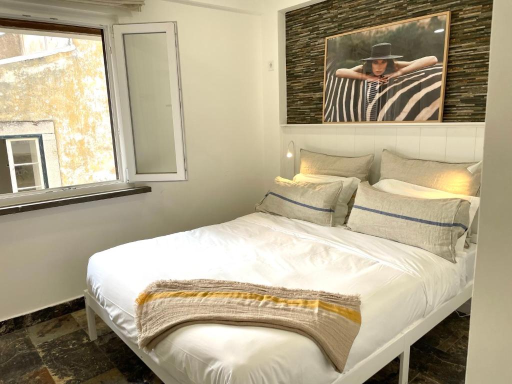 un letto bianco in una stanza con finestra di Luxury apartment in center Cascais a Cascais