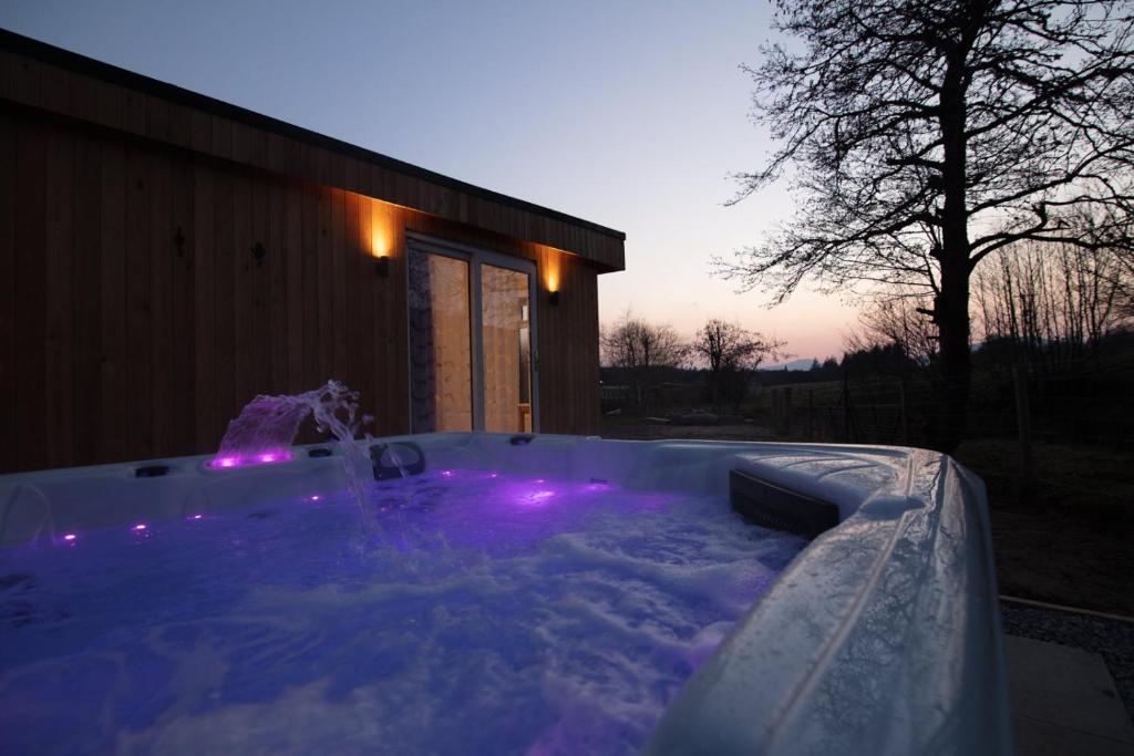 a hot tub with purple lights in front of a house at Allt Mor Rentals - Chalet with hot tub, And Studio Apartment with balcony in Roybridge