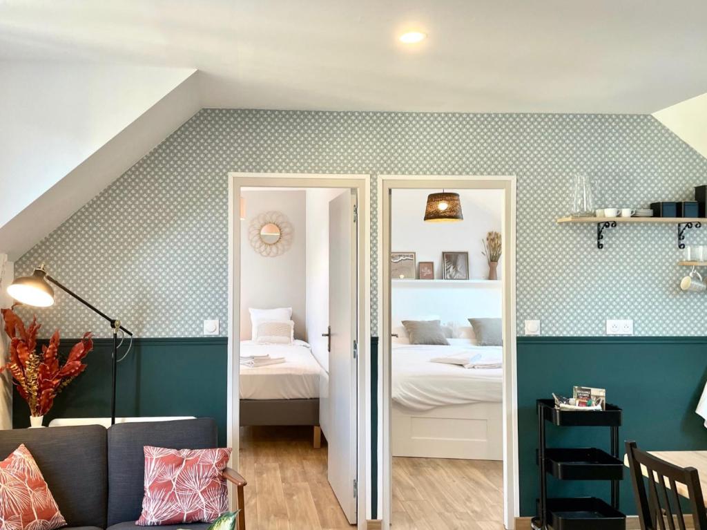 ein Wohnzimmer mit einem Bett und ein Zimmer mit einem Bett in der Unterkunft Émeraude Lumineux T3 au cœur du village, à 5 min des plages in Saint-Méloir-des-Ondes
