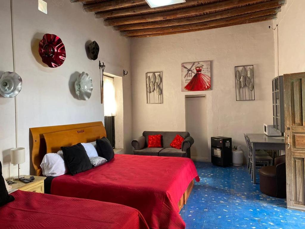 a bedroom with two beds and a red blanket at Casa Rivera Díaz Habitacion Diamante in Parras de la Fuente