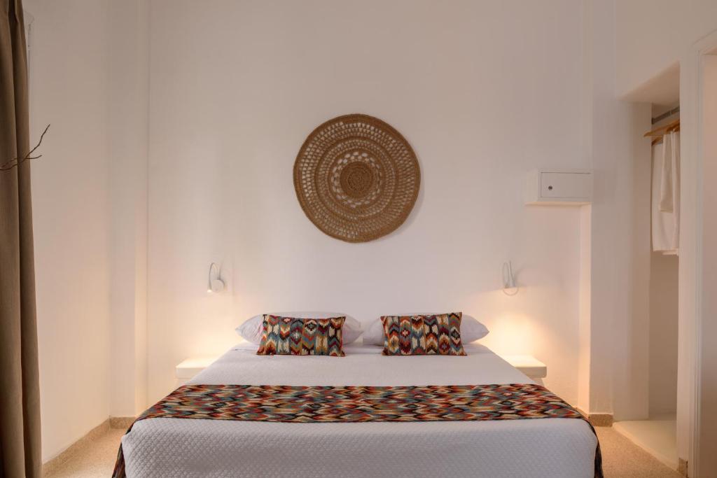 a bedroom with a bed and a picture on the wall at Cal Day Rooms Santorini in Perissa
