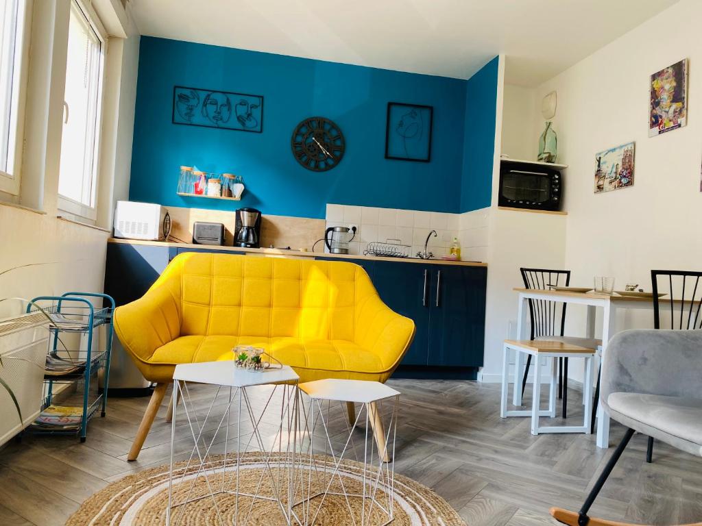 a living room with a yellow couch and a kitchen at Très bel appartement Dunkerque centre, en Citadelle in Dunkerque