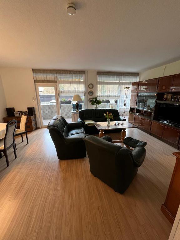 a living room with black leather furniture and a table at Fewo Berlik in Bad Harzburg