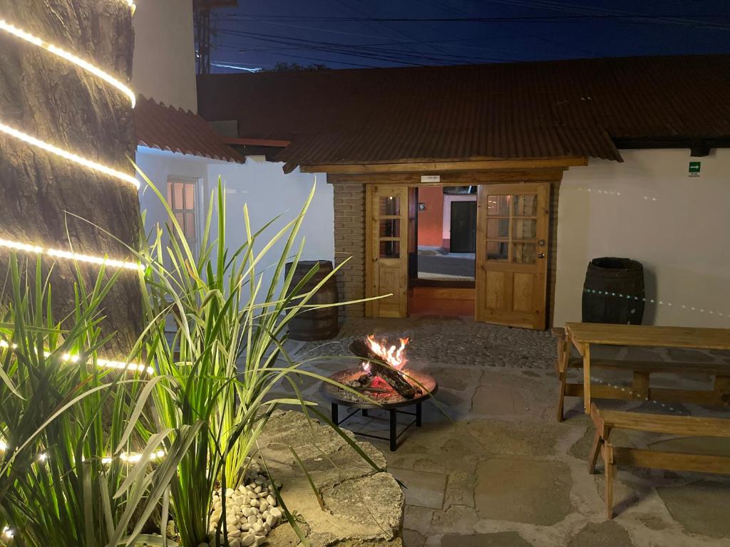 Eine Feuerstelle mitten auf der Terrasse mit einer Bank in der Unterkunft Casa Valentino Trattoria & Alojamiento in Mineral del Monte
