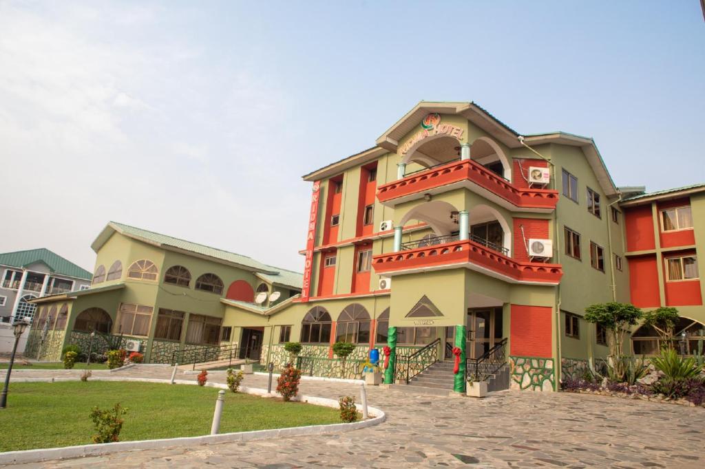 RIDMA HOTEL في آكرا: مبنى كبير باللون الأحمر والأخضر