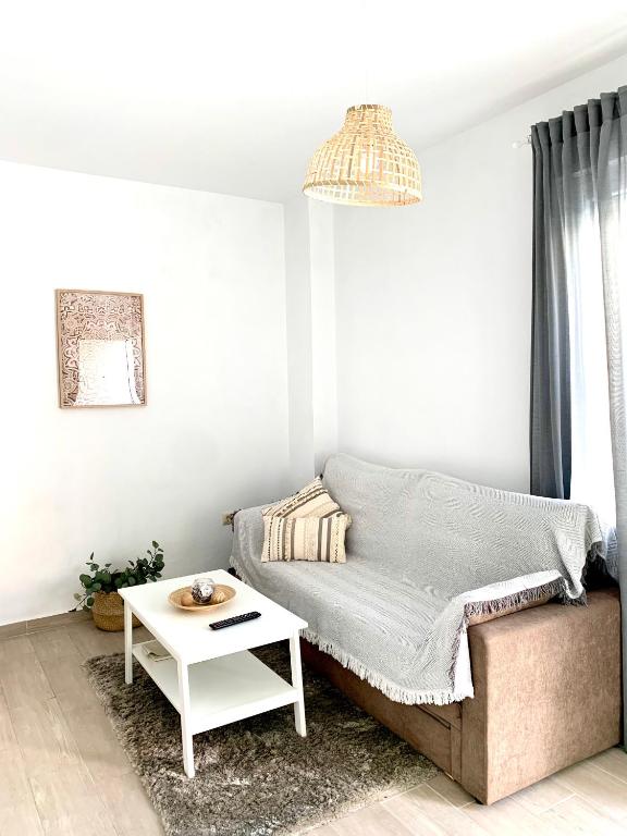 a living room with a couch and a table at Apartamento Puerta Al Mar in Tarifa
